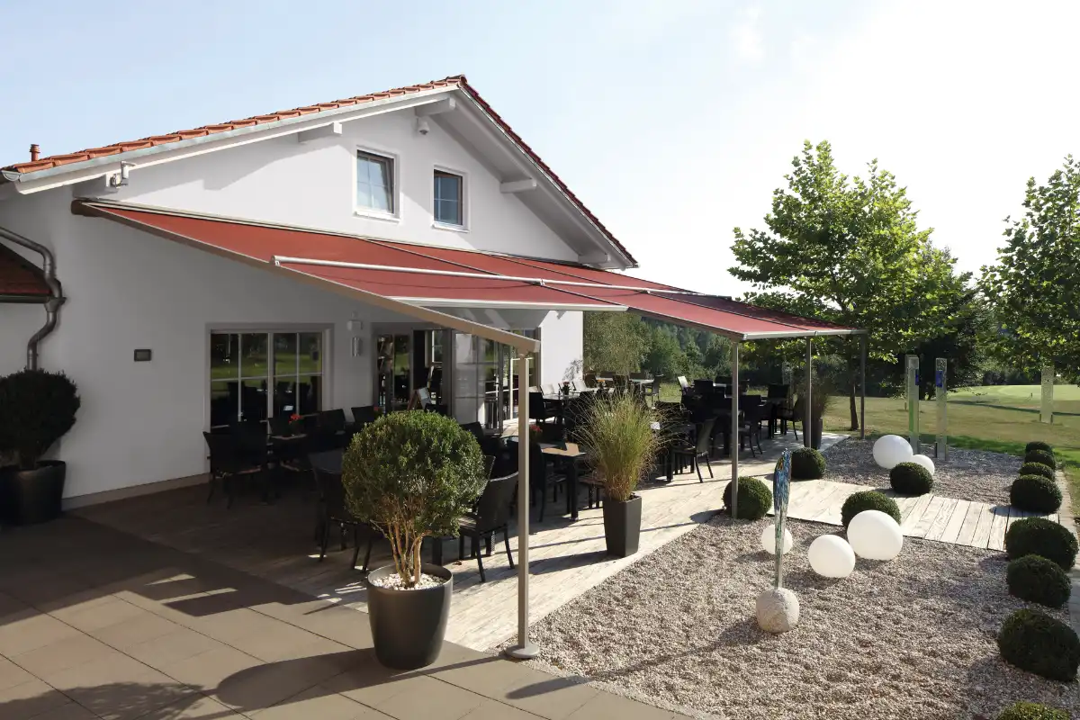 Terrasse eines modernen Hauses mit Sonnenschutz und stilvollen Pflanzen